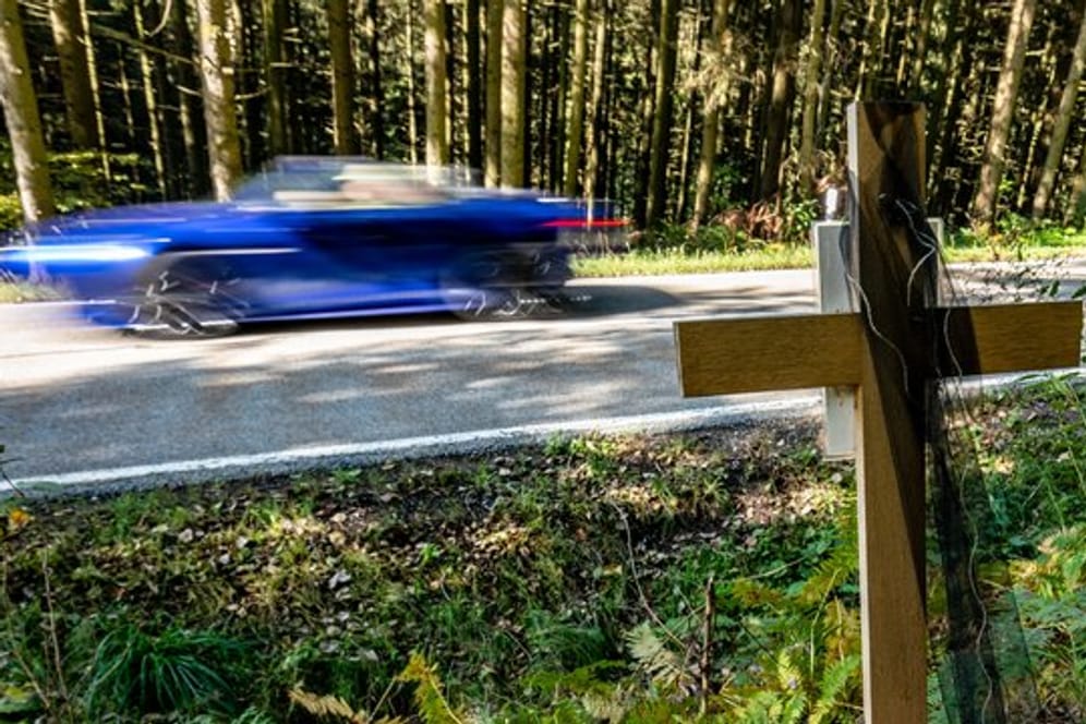 Ein Holzkreuz steht bei Achslach an der Stelle, an der die Männer bei einem Rennen den Tod eines weiteren Autofahrers verursacht haben sollen.