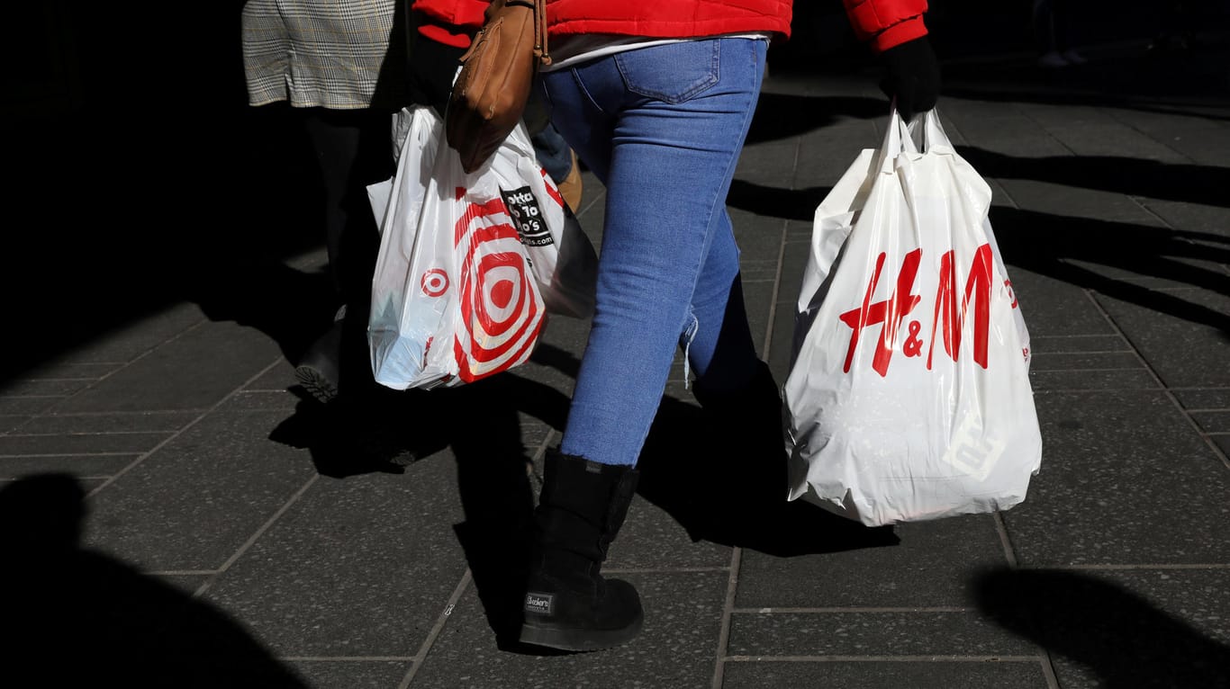 Eine Frau mit Einkaufstüten läuft über die Straße: Vor dem US-Feiertag Thanksgiving locken viele Händler am sogenannten "Black Friday" mit Sonderangeboten.