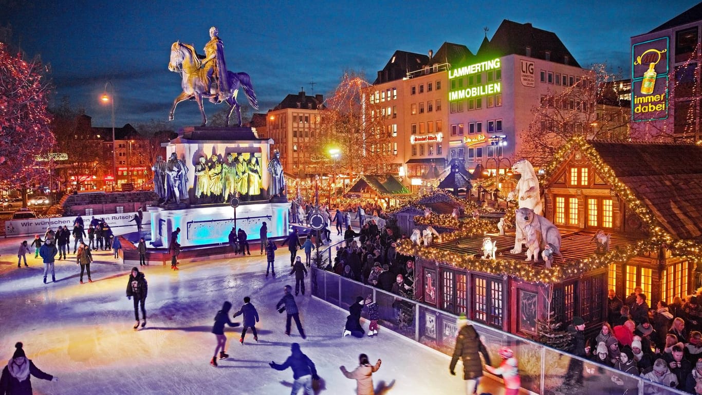 Menschen auf der illuminierten Eisbahn auf dem Heumarkt: Schlittschuhlaufen auf dem Weihnachtsmarkt ist besonders beliebt.