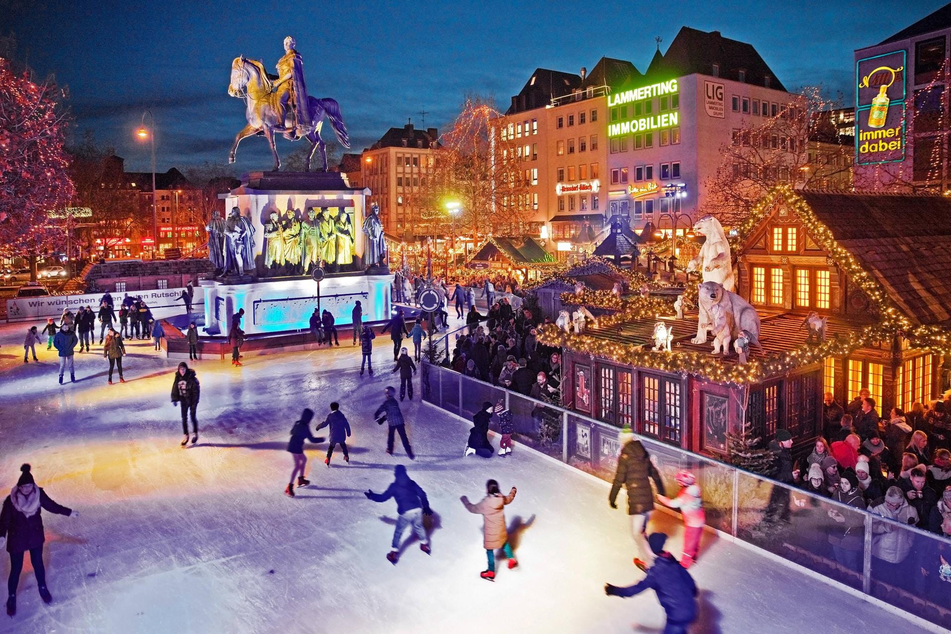 Menschen auf der illuminierten Eisbahn auf dem Heumarkt: Schlittschuhlaufen auf dem Weihnachtsmarkt ist besonders beliebt.