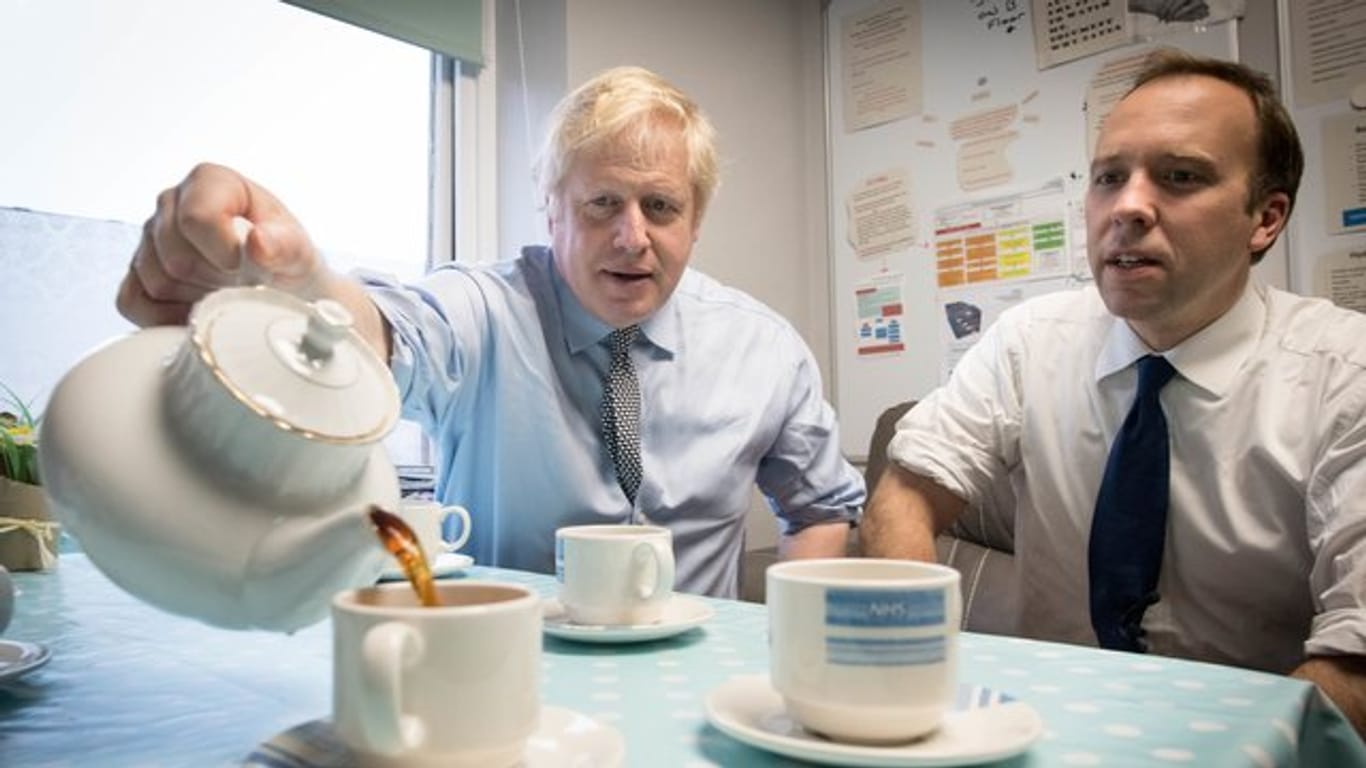 Premierminister Boris Johnson und Gesundheitsminister Matt Hancock widmen sich beim Besuch eines Krankenhauses einer britischen Tradition - dem Teetrinken.