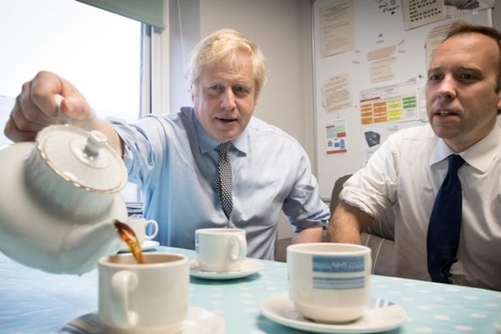 Premierminister Boris Johnson und Gesundheitsminister Matt Hancock widmen sich beim Besuch eines Krankenhauses einer britischen Tradition - dem Teetrinken.