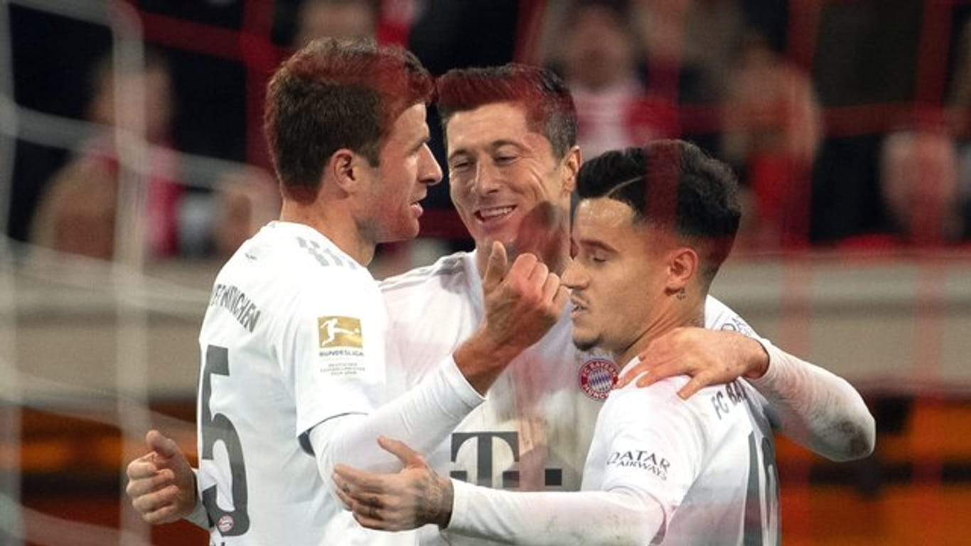 Die Münchner Thomas Müller (l), Philippe Coutinho (r) und Robert Lewandowski feiern das 4:0.
