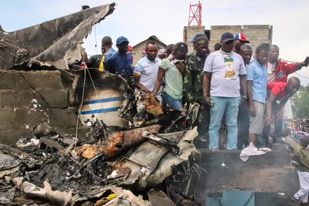 Abgestürztes Flugzeug: Anwohner betrachten die Stelle, an der das Flugzeug auf ein Wohngebiet abgestürzt ist.