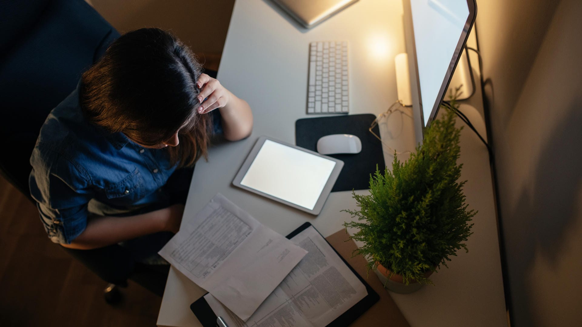 Eine junge Frau arbeitet spät am Abend: Emotionale Erschöpfung kann durch eine schlechte Work-Life-Balance entstehen.