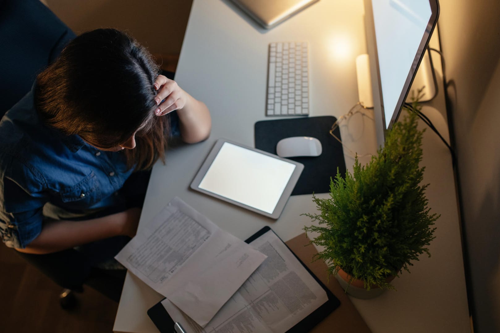 Eine junge Frau arbeitet spät am Abend: Emotionale Erschöpfung kann durch eine schlechte Work-Life-Balance entstehen.