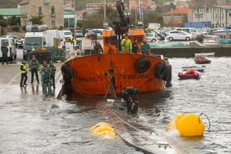 Ein Schlepper der Guardia Civil zieht ein gut 20 Meter langes Drogen-U-Boot aus dem Wasser, das vor der Küste der Region Galicien abgefangen worden war.