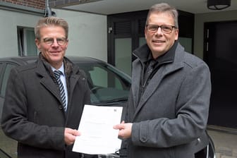 Markus Coerdt, Hauptdezernent der Bezirksregierung Arnsberg, übergibt Stadtrat Arnulf Rybicki den vorerst letzten Fördermittelbescheid für Elektrofahrzeuge.