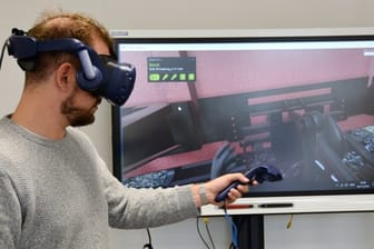 Im Trainingszentrum der Deutschen Bahn können Auszubildende mit einer VR-Brille üben, Güterwaggons aneinanderzukoppeln.