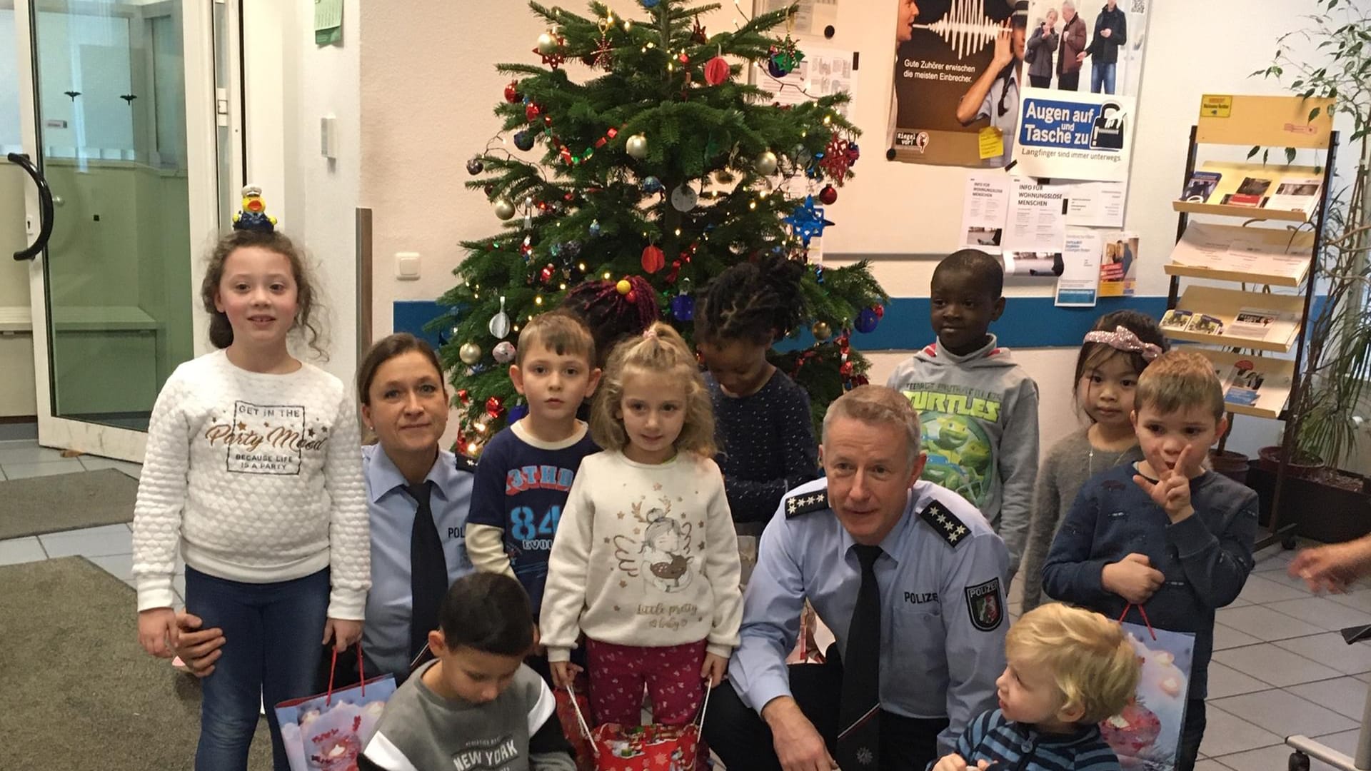 Vorschulkinder stehen vor einem Baum: In der Polizeiwache in Elberfeld durften sie diesen mit Schmuck verzieren.