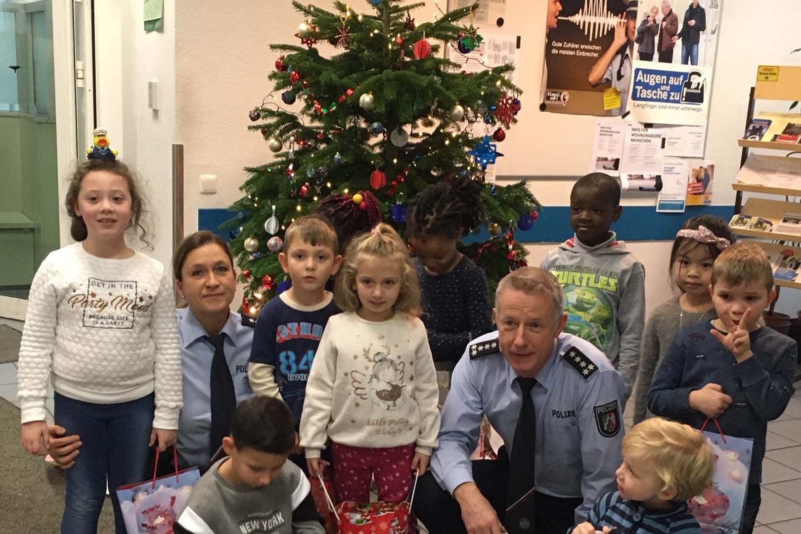 Vorschulkinder stehen vor einem Baum: In der Polizeiwache in Elberfeld durften sie diesen mit Schmuck verzieren.