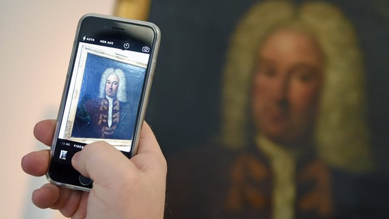 Ein Museums-Besucher macht ein Foto mit dem Handy: Wer zum Auslösen nicht auf das Display tippen will, kann zum Fotografieren auch die Lautstärke-Wippe nutzen.