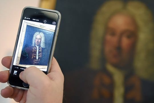 Ein Museums-Besucher macht ein Foto mit dem Handy: Wer zum Auslösen nicht auf das Display tippen will, kann zum Fotografieren auch die Lautstärke-Wippe nutzen.