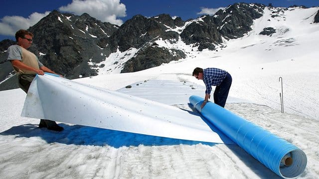 Retten, was zu retten ist: Helfer rollen im Hochsommer schützende Planen auf dem Tortin-Gletscher in der Schweiz aus. Retten, was zu retten ist: Helfer rollen im Hochsommer schützende Planen auf dem Tortin-Gletscher in der Schweiz aus.
