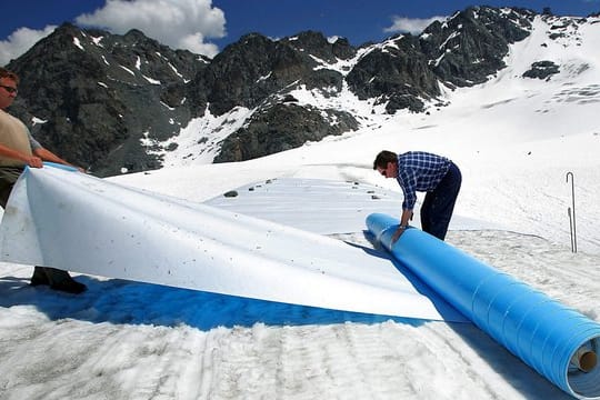 Retten, was zu retten ist: Helfer rollen im Hochsommer schützende Planen auf dem Tortin-Gletscher in der Schweiz aus.