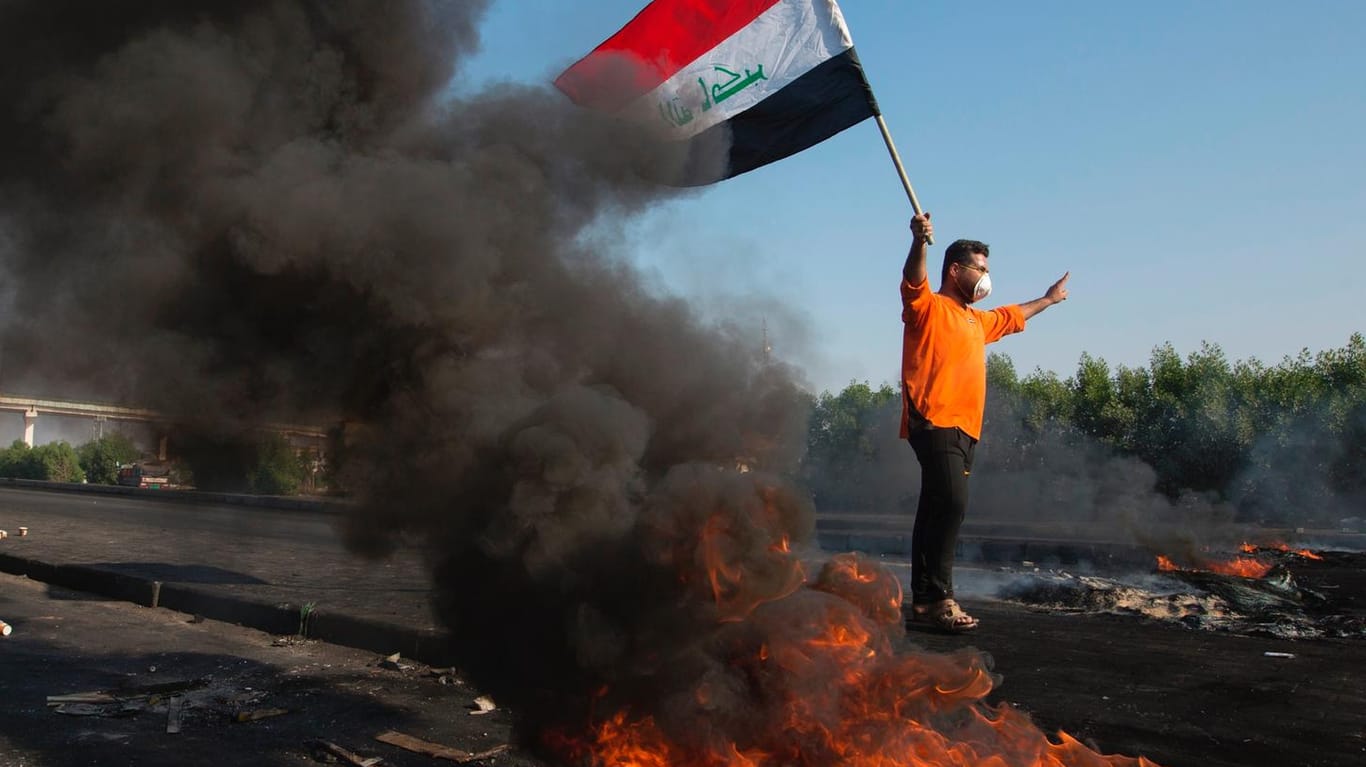 Demonstrant mit Mundschutz und irakischer Flagge in Basra: Seit zwei Monaten gehen die Menschen im Irak auf die Straßen, mehr als 360 wurden seither getötet.