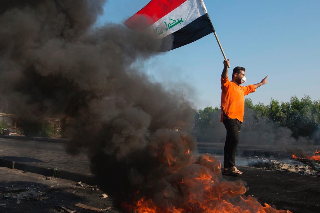 Demonstrant mit Mundschutz und irakischer Flagge in Basra: Seit zwei Monaten gehen die Menschen im Irak auf die Straßen, mehr als 360 wurden seither getötet.