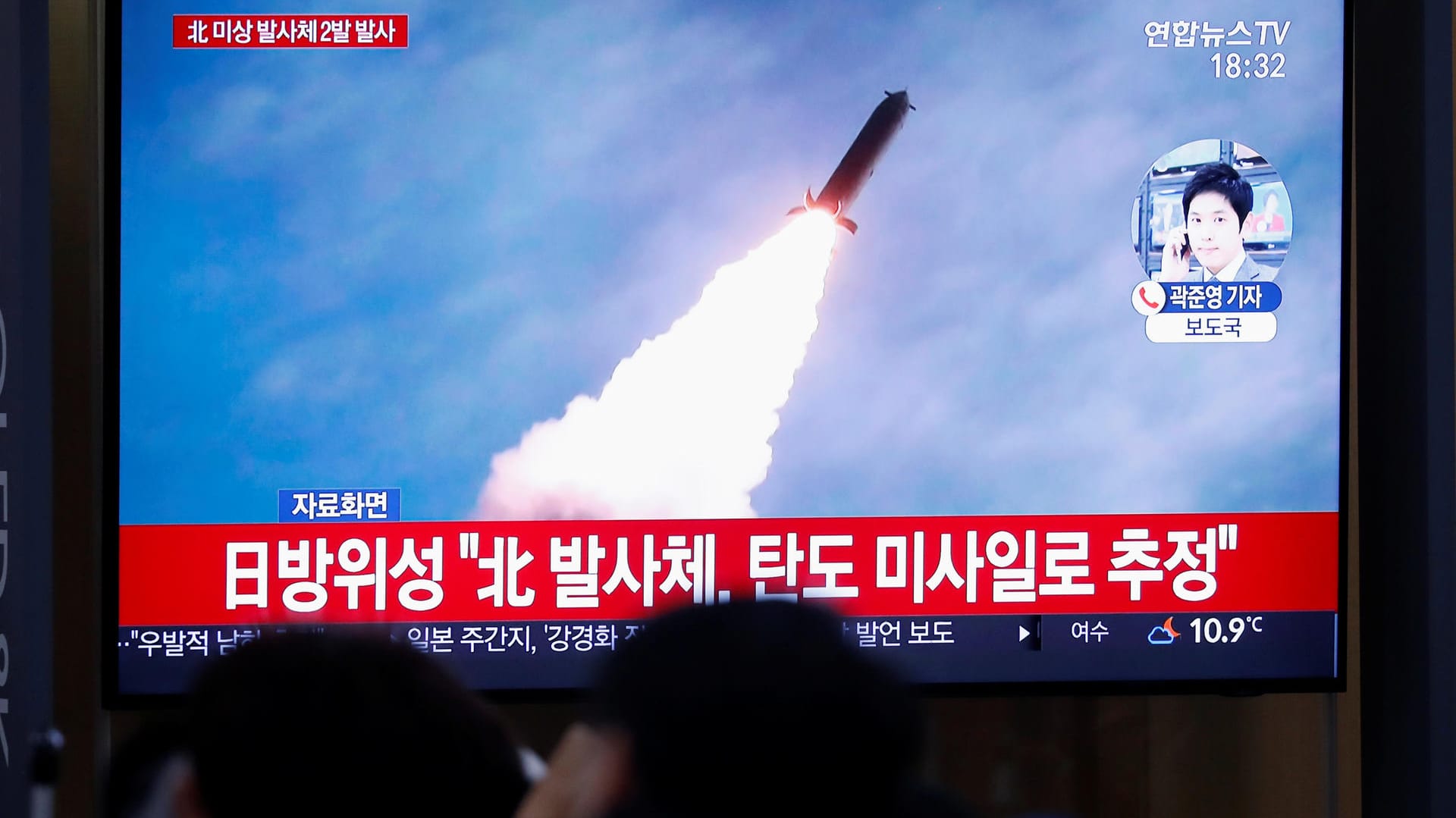 Straßenszene in Südkoreas Hauptstadt Seoul: Passanten verfolgen in den Nachrichten den Abschuss einer Rakete in Nordkorea.