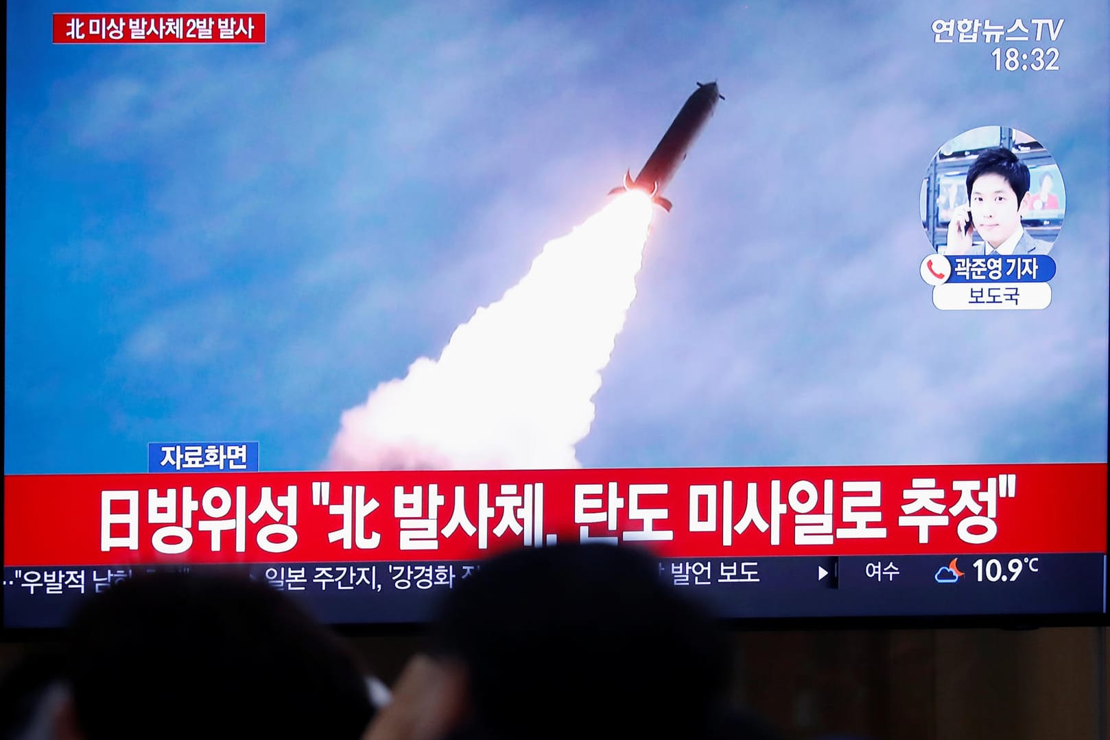 Straßenszene in Südkoreas Hauptstadt Seoul: Passanten verfolgen in den Nachrichten den Abschuss einer Rakete in Nordkorea.