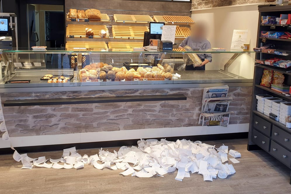 Kassenbons vor Bäckertresen: Bäckermeister Michael Tenk findet die gesetzliche Vorschrift, ab 2020 für jedes verkaufte Brötchen einen Kassenbon ausdrucken zu müssen, Wahnsinn: Schon nach zwei Tagen sammelt sich ein Papierberg von 600 Zetteln an.