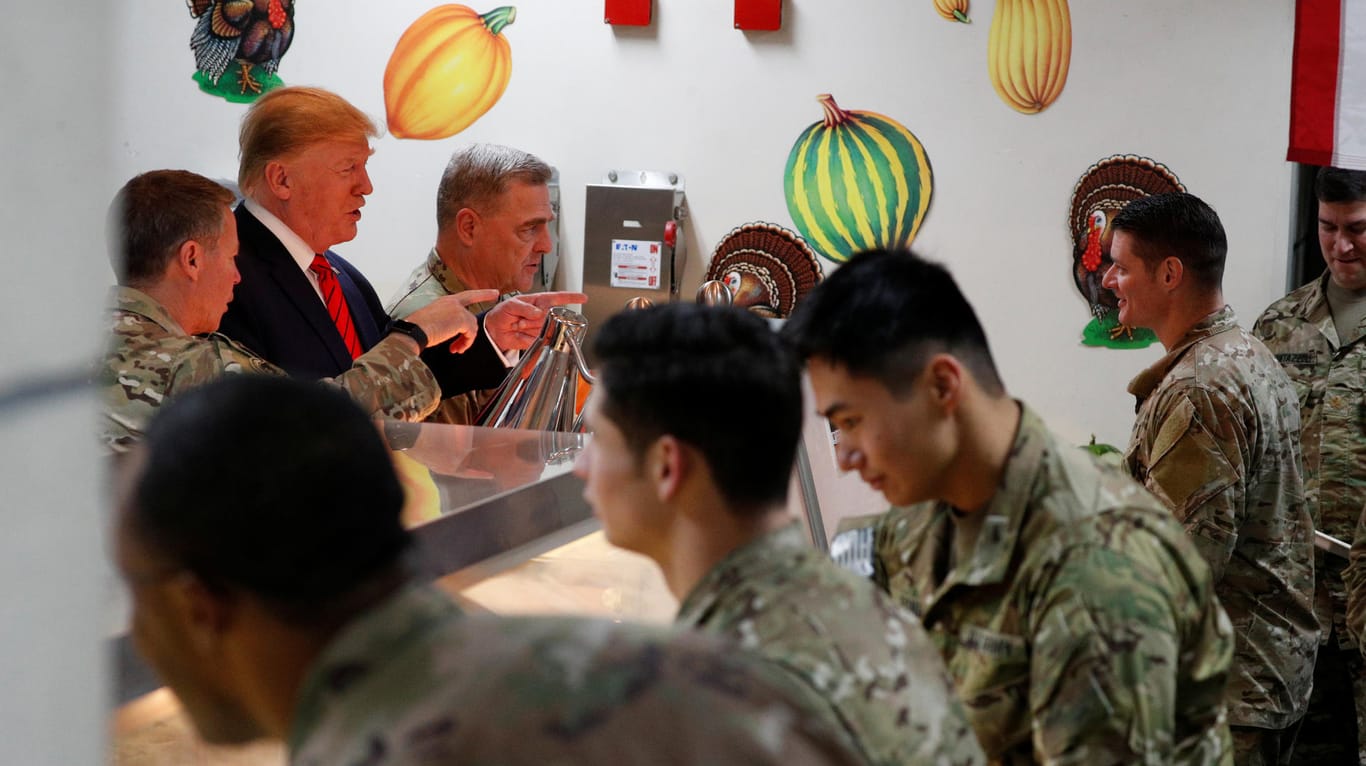 Donald Trump teilt den Soldaten in der Cafeteria der Militärbasis das Thanksgiving-Essen aus.