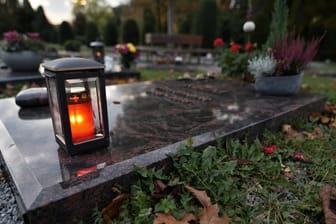 Eine Grabkerze auf einem Friedhof: In Hagen haben bisher Unbekannte Täter eine Statue von einem Grab gestohlen.