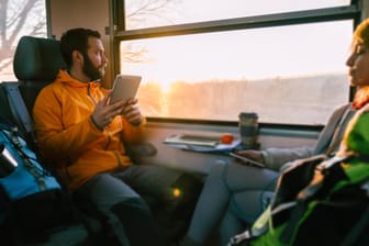Ein Mann nutzt sein Tablet im Zug: Die Telekom wertet ihre reinen Datentarife auf.