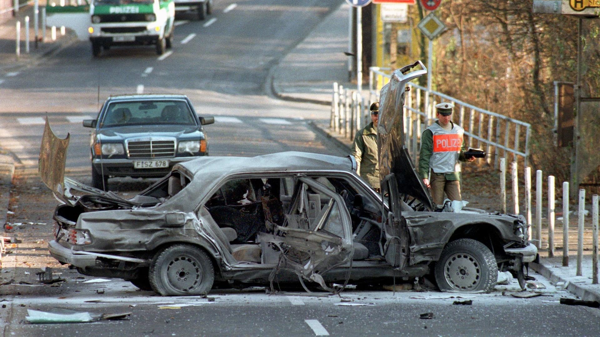 Polizeibeamte stehen in Bad Homburg neben dem Wrack der Herrhausen-Limousine: Die RAF hat führende Repräsentanten aus Wirtschaft und Staat ermordet.