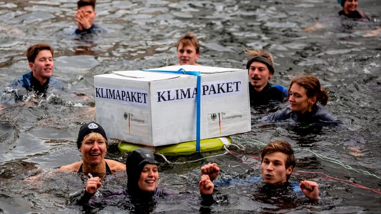 Aktivisten schwimmen bei winterlichen Temperaturen in der Spree: Sie protestieren gegen das Klimapaket der deutschen Bundesregierung.