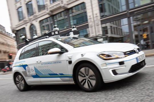 Ein Elektro-Golf, bestückt mit Laserscannern, Kameras, Ultraschallsensoren und Radar für vollautomatisches Fahren, ist bei einer Testfahrt in der Innenstadt unterwegs.