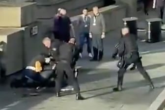 Angriff auf der London Bridge: Die Standaufnahme eines Videos zeigt, wie Polizisten Passanten von dem Angreifer entfernen.