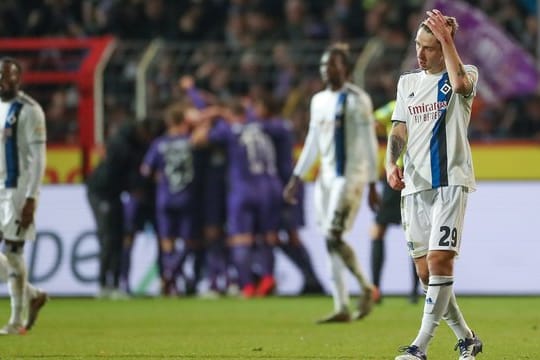 Während im Hintergrund die Osnabrücker Spieler feiern lassen die Hamburger die Köpfe hängen.