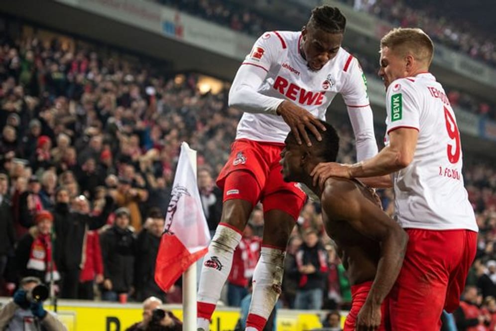 Die Kölner Kingley Ehizibue (l) und Simon Terodde (r) feiern mit Torschütze Jhon Cordoba den Treffer zum 1:1 Ausgleich.