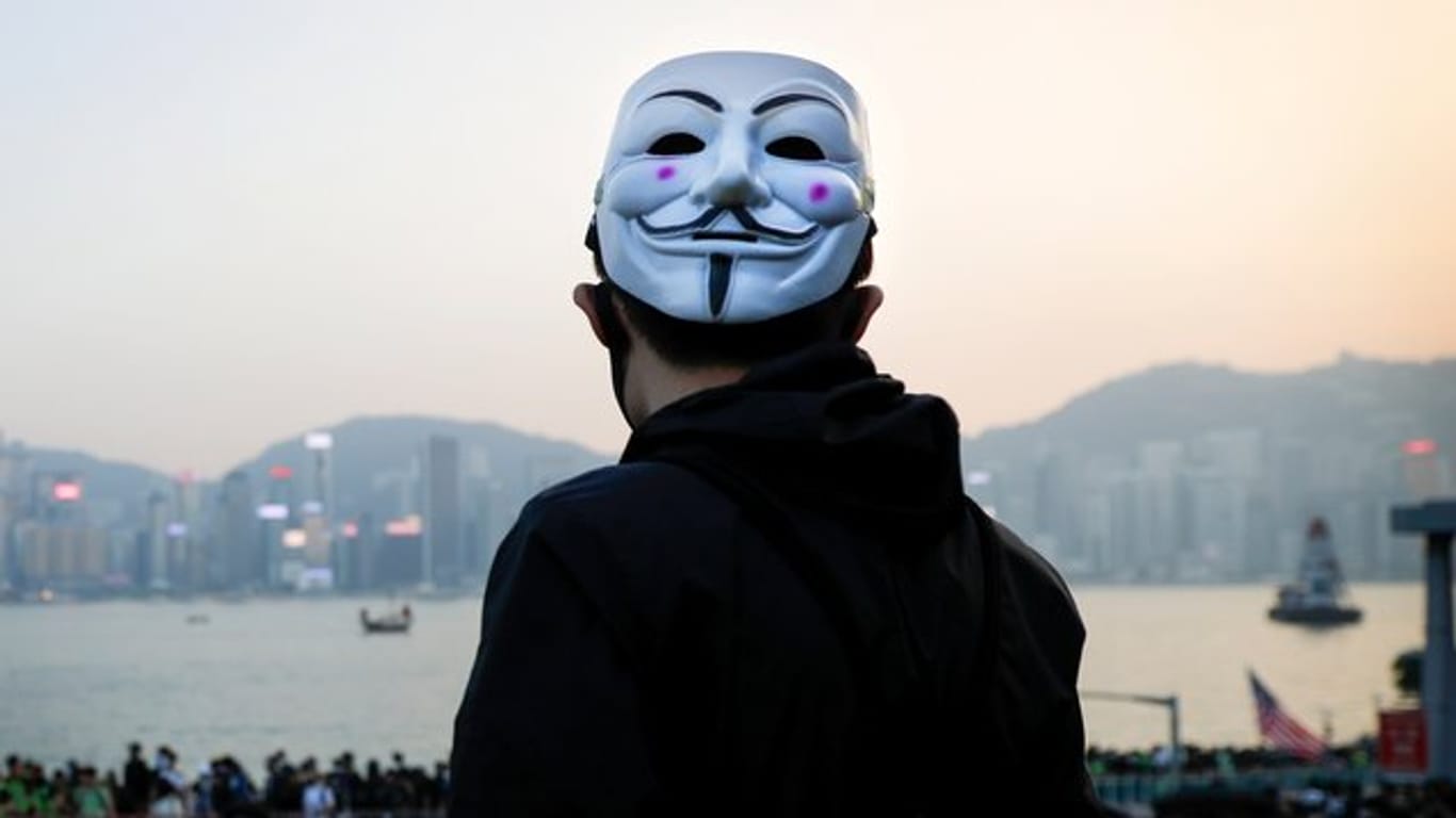 Ein prodemokratischer Demonstrant mit Guy-Fawkes-Maske beobachtet eine Kundgebung in Hongkong.