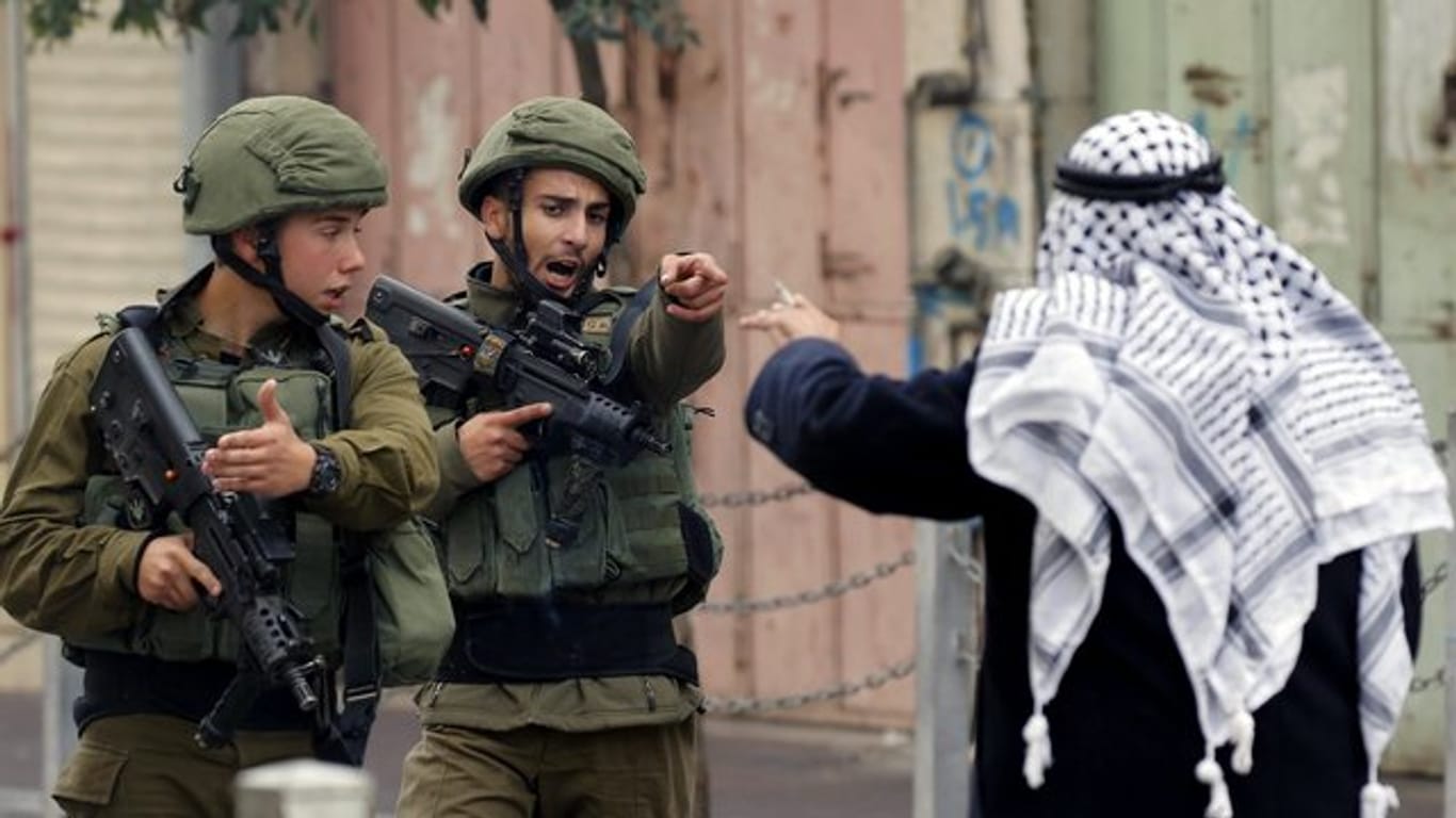 Ein Mann streitet in Hebron im Westjordanland mit israelischen Soldaten.