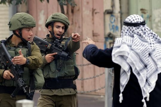 Ein Mann streitet in Hebron im Westjordanland mit israelischen Soldaten.