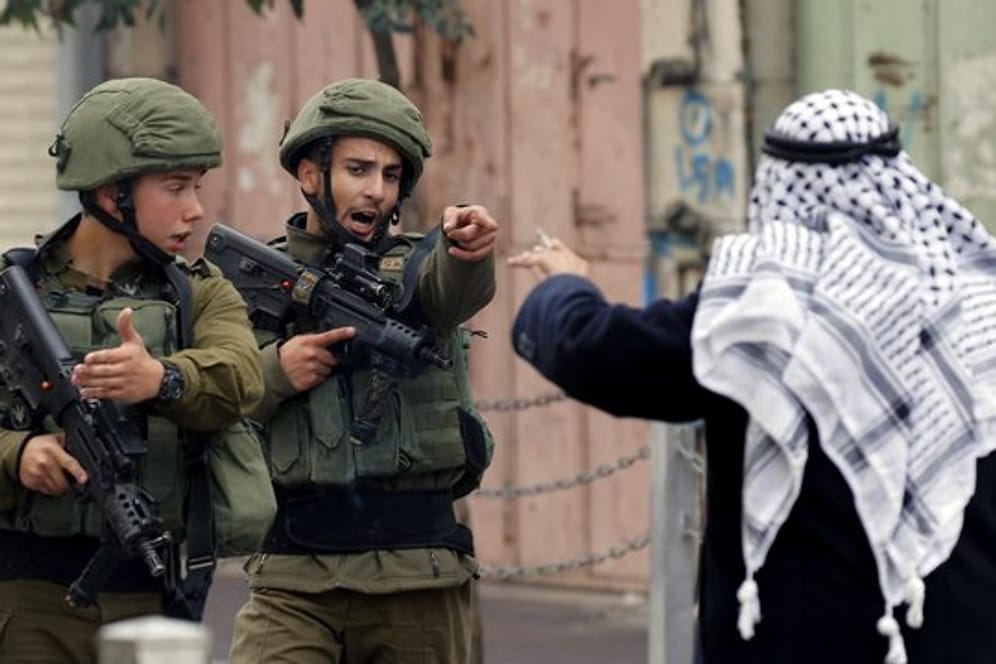 Ein Mann streitet in Hebron im Westjordanland mit israelischen Soldaten.