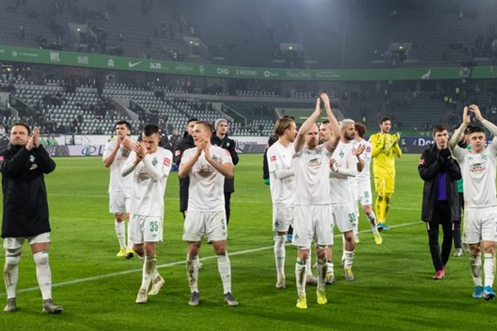 Die Spieler von Werder Bremen feiern den Sieg in Wolfsburg vor ihrer Fankurve.