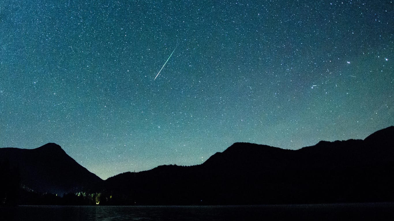 Eine Sternschnuppe leuchtet vor der Milchstraße am Himmel über dem Walchensee: Im Dezember gibt es einiges am Sternenhimmel zu sehen.