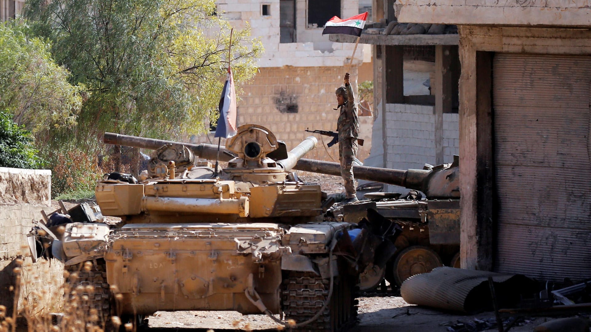 Ein Soldat steht in Idlib auf einem Panzer und hält eine syrische Flagge hoch: Regierungstruppen und verbündete Milizen gingen gegen Rebellen vor. (Archivbild)