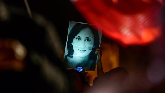 Mit einem Bild der ermordeten Reporterin Daphne Caruana Galizia haben sich Demonstranten vor dem Büro des maltesischen Premierministers postiert.