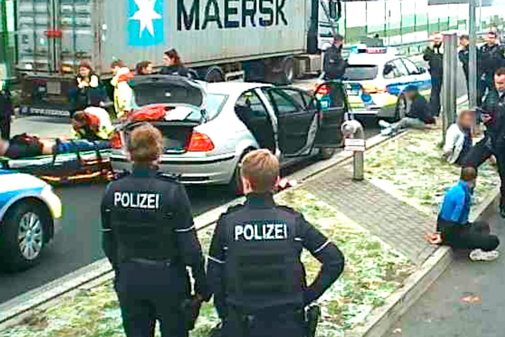 Nach der Massenschlägerei auf einem Parkplatz in Bochum: Festgenommene werden bewacht, Verletzte abtransportiert.