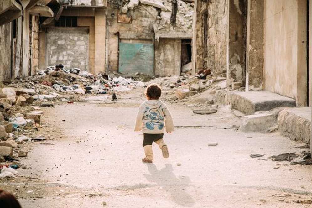 Ein kleiner Junge geht durch eine vom Bürgerkrieg zerstörte Straße in der syrischen Metropole Aleppo.