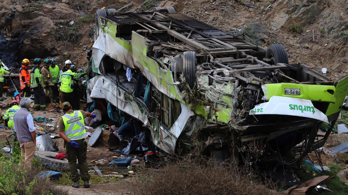 Rettungskräfte arbeiten an der Stelle, an der ein Fernbus 30 Meter in die Tiefe gestürzt ist: Weitere 21 Menschen wurden bei dem Unglück verletzt.