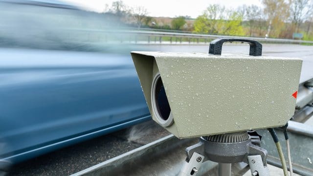 Ein blaues Auto fährt an einem Blitzer vorbei (Symbolbild): Am Freitag wird in Frankfurt und auf einigen Autobahnen geblitzt.