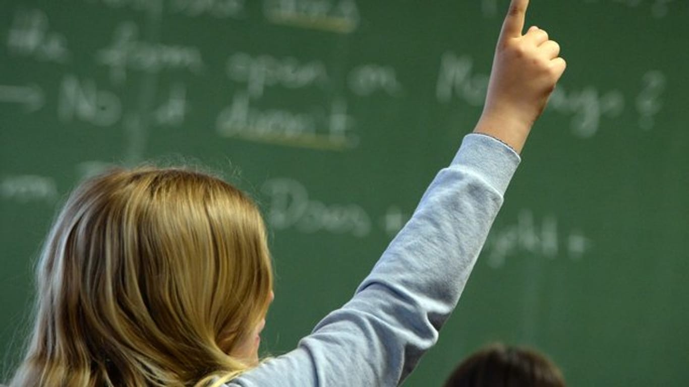 Eine Schülerin meldet sich in einem Klassenzimmer in einem Gymnasium während des Englischunterrichts.