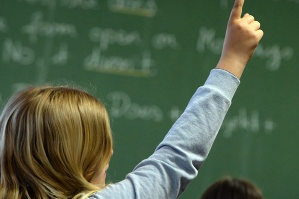 Eine Schülerin meldet sich in einem Klassenzimmer in einem Gymnasium während des Englischunterrichts.