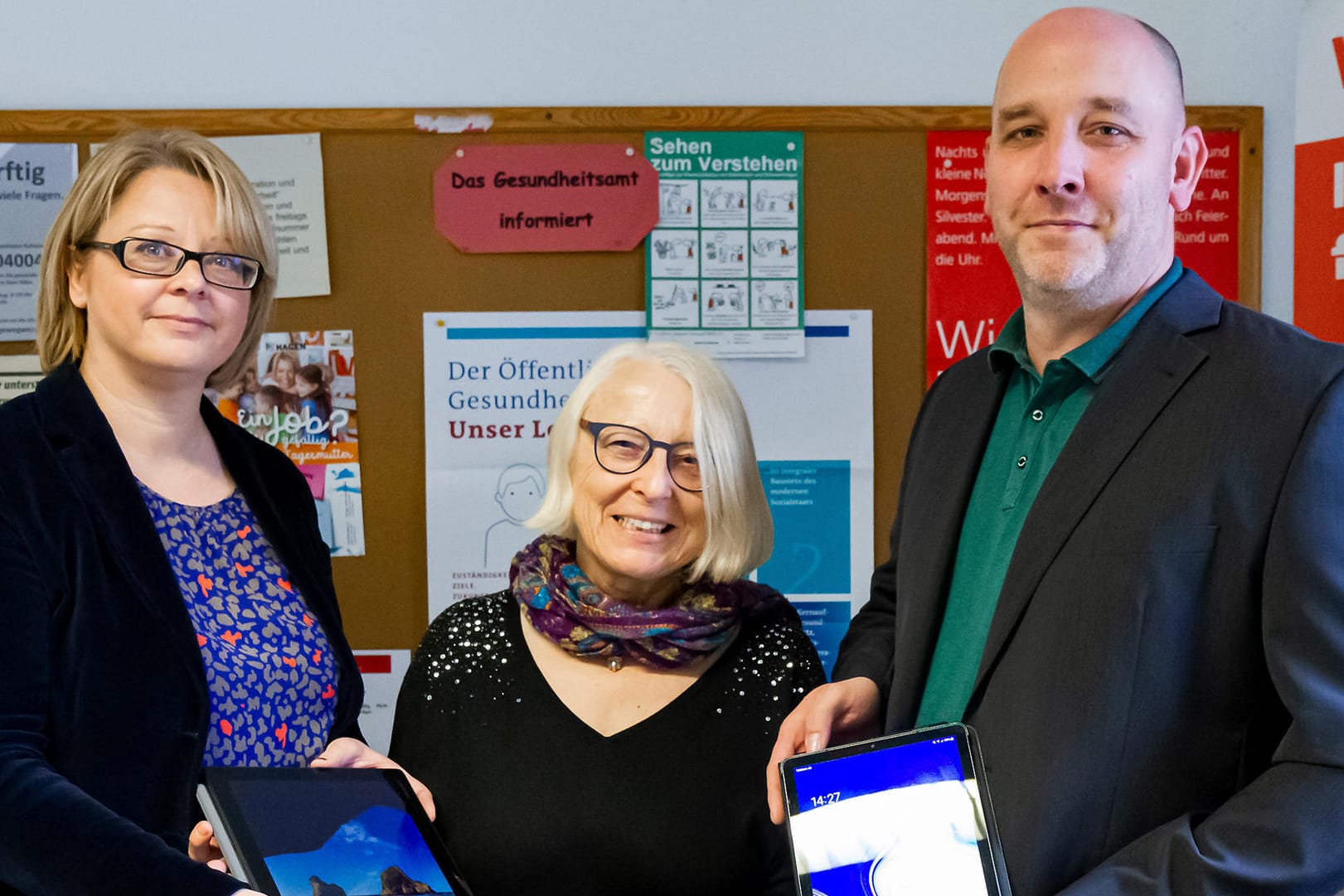 Anke May (Teamleitung Verwaltung und Gesundheitsförderung), Dr. Claudia Sommer (Bereichsleiterin Gesundheit und Verbraucherschutz) und Christian Lazar (Leiter Task Force Digitalisierung): Sie zeigen die neuen Tablets für die Lebensmittelkontrolleure.