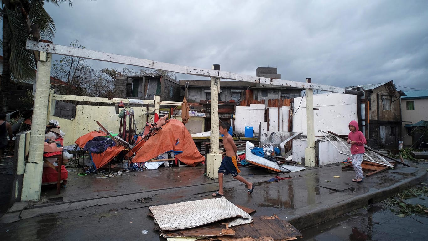 Kinder vor einem beschädtigten Haus: Der Sturm sorgte für Zerstörung, Überschwemmungen und Stromausfälle in dem Inselstaat.