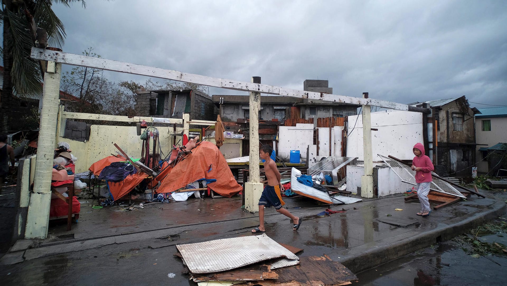 Kinder vor einem beschädtigten Haus: Der Sturm sorgte für Zerstörung, Überschwemmungen und Stromausfälle in dem Inselstaat. Kinder vor einem beschädtigten Haus: Der Sturm sorgte für Zerstörung, Überschwemmungen und Stromausfälle in dem Inselstaat.